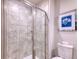 Tiled shower with a glass door, a window, and a framed art piece at 2557 7B Pete Dye Dr. # 704, North Myrtle Beach, SC 29582