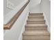Carpeted staircase with a wooden handrail and white risers leads to the upper level of the home at 794 Nw Palm Frond Way # 48, Calabash, NC 28467