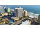 Aerial shot capturing a beachfront condo with a pool, beach access, and beautifully landscaped surroundings at 1207 S Ocean Blvd. # 51408, Myrtle Beach, SC 29577