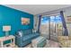 Cozy living room featuring blue walls, a comfortable sofa, and balcony access with beautiful views at 1207 S Ocean Blvd. # 51408, Myrtle Beach, SC 29577