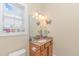Bright bathroom featuring a single sink vanity, decorative mirror, and window with blinds at 136 Kenzgar Dr., Myrtle Beach, SC 29588