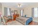 Bedroom features a bed, dresser, hardwood floors, a ceiling fan, and natural light from two windows at 136 Kenzgar Dr., Myrtle Beach, SC 29588