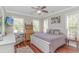 Bright bedroom featuring wood floors, a white bed frame, and sunlit windows with views of the outdoors at 136 Kenzgar Dr., Myrtle Beach, SC 29588