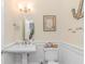 Charming powder room with a pedestal sink, beadboard paneling, decorative mirror, and coastal-themed accents at 136 Kenzgar Dr., Myrtle Beach, SC 29588