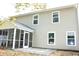 Tan two-story home featuring white trim windows and a screened-in porch for relaxing outdoors at 156 Weeping Willow Dr., Myrtle Beach, SC 29579