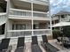 View of the exterior of the building with balconies, lounge chairs and tables at 2805 N Ocean Blvd. # 107, Myrtle Beach, SC 29577