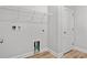 Well-lit laundry room features a wire rack shelf, wooden floors, and white trim at 608 Britt St., Georgetown, SC 29440