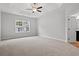 Spacious main bedroom boasts a tray ceiling with fan, plush carpeting, and backyard window at 608 Britt St., Georgetown, SC 29440