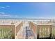 Wooden walkway leads to a sandy beach with ocean views and grassy dunes at 1501 Ocean Blvd. S # 422, Myrtle Beach, SC 29577