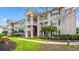 Low angle view of a condo building with multiple balconies and green trim, surrounded by grass and landscaping at 3735 Block House Way # 113, Myrtle Beach, SC 29577