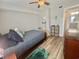 Bedroom features a ceiling fan, wood-look flooring, bed, window and view into bathroom at 8830 Chandler Dr. # G, Surfside Beach, SC 29575