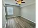 Bedroom featuring wood-look flooring, a ceiling fan, a large window and closet doors at 8830 Chandler Dr. # G, Surfside Beach, SC 29575