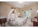 Cozy bedroom with floral bedding, decorative wall sconces, and a window overlooking the yard at 1716 Club Circle Dr., Pawleys Island, SC 29585