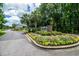 Landscaped community entrance sign with colorful flowers, palm trees, and a guard house at 1716 Club Circle Dr., Pawleys Island, SC 29585