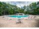 Large community swimming pool surrounded by lounge chairs and mature trees on a sunny day at 1716 Club Circle Dr., Pawleys Island, SC 29585