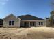 A single-story home has beige siding, a dark roof, an open back porch, and several dark trimmed double hung windows at 3174 Wayside Rd., Conway, SC 29527