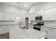 Modern kitchen with white cabinets, granite island, and stainless steel appliances at 387 Lifestyle Court, Surfside Beach, SC 29575