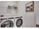 Bright laundry room features modern Whirlpool washer and dryer, with shelving for storage and decor at 8636 Farrier Dr., Myrtle Beach, SC 29588