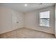 A bright bedroom boasts a window, double-door closet, and neutral carpeting at 8648 Farrier Dr., Myrtle Beach, SC 29588