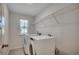 Well-lit laundry room with washer, dryer, and overhead storage at 8648 Farrier Dr., Myrtle Beach, SC 29588