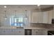 An open-concept kitchen boasting stainless steel appliances, white cabinets, modern countertops, and views of the living area at 8652 Farrier Dr., Myrtle Beach, SC 29588