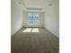 Bright bedroom with neutral carpet, a tray ceiling, and a large window at 8663 Farrier Dr., Myrtle Beach, SC 29588