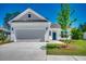Charming one-story home featuring a two-car garage, blue front door, and professionally landscaped yard at 8667 Farrier Dr., Myrtle Beach, SC 29588