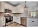 Well-lit kitchen showcasing white cabinets, stainless appliances, decorative backsplash, and wood flooring at 8667 Farrier Dr., Myrtle Beach, SC 29588