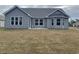 Rear exterior showcasing gray siding, an open backyard and an intimate covered patio at 910 Padgett Lane, Conway, SC 29526