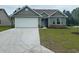 Charming single-story home with green siding, stone accents, a white garage door, and a well-maintained front lawn at 910 Padgett Lane, Conway, SC 29526