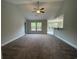 Bright living room featuring neutral walls, carpet floors, a ceiling fan, and seamless access to the kitchen at 910 Padgett Lane, Conway, SC 29526