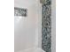A close-up of the shower featuring white tile and blue decorative tile at 9581 Shore Dr. # 132, Myrtle Beach, SC 29572