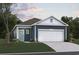 Charming home featuring a two-car garage, blue siding, and manicured landscaping at 4009 Braid Ct., Myrtle Beach, SC 29588