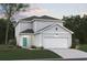 Two-story home featuring a two-car garage, light gray siding, a well-manicured lawn, and an inviting front door at 4009 Braid Ct., Myrtle Beach, SC 29588