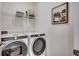 Practical laundry room with modern washer and dryer, storage shelves, and ample space for laundry tasks at 4009 Braid Ct., Myrtle Beach, SC 29588