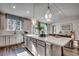 Beautiful kitchen with a large center island, white cabinetry, modern pendant lights, and open view to the living area at 8644 Farrier Dr., Myrtle Beach, SC 29588