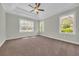 Spacious bedroom with carpet, many large windows, a ceiling fan, and tray ceiling feature at 2588 Lake Vista Dr., Little River, SC 29566