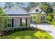 Beautiful home exterior showing the landscaped yard, light colored exterior, and black shutters at 2588 Lake Vista Dr., Little River, SC 29566