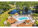 Aerial view of pool featuring patio seating, sun loungers, beautiful landscaping, and lake in background at 2588 Lake Vista Dr., Little River, SC 29566