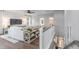 Open-concept living room with shiplap accent wall, stylish décor, and modern ceiling fan; view from second floor landing at 622 Braselton Ln., Myrtle Beach, SC 29588