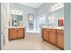 Bathroom featuring a soaking tub between two vanities with storage, a stained glass window, and tiled flooring at 1066 Brentford Pl., Myrtle Beach, SC 29579