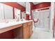 Bathroom with red walls, vanity with white countertop, glass enclosed shower, and a decorative red and white theme at 1066 Brentford Pl., Myrtle Beach, SC 29579