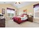 Bedroom featuring a vaulted ceiling, two windows and decoratively dressed bed with red accents and side tables at 1066 Brentford Pl., Myrtle Beach, SC 29579