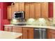 Close up of wooden kitchen cabinets and countertops with a tiled backsplash and stainless steel appliances at 1066 Brentford Pl., Myrtle Beach, SC 29579