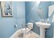 Cozy powder room with light blue walls, pedestal sink, and decorative mirror at 1066 Brentford Pl., Myrtle Beach, SC 29579