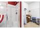 Tiled walk-in shower with glass door and open doorway leading to a closet with wire shelving for organization at 1066 Brentford Pl., Myrtle Beach, SC 29579