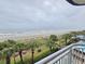 Beautiful beach view from the balcony of a high-rise resort with palm trees and beach access at 2007 S Ocean Blvd. # 401, Myrtle Beach, SC 29577