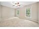 A bright bedroom with neutral carpet, a ceiling fan and two windows with outdoor views at 3034 Oak Grove Bend # 34 Ar, Murrells Inlet, SC 29576