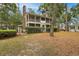A beautiful two-story home with screened porches surrounded by mature trees and greenery at 3034 Oak Grove Bend # 34 Ar, Murrells Inlet, SC 29576