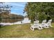 Relaxing view of a serene lake with four white rocking chairs on the grassy bank at 3034 Oak Grove Bend # 34 Ar, Murrells Inlet, SC 29576